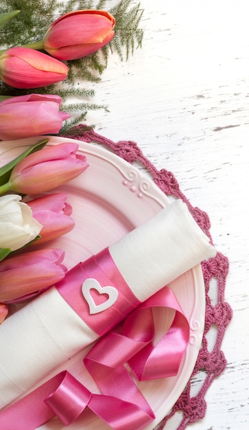 Réglage de la table romantique avec des fleurs de tulipes et une vue de dessus du ruban rose