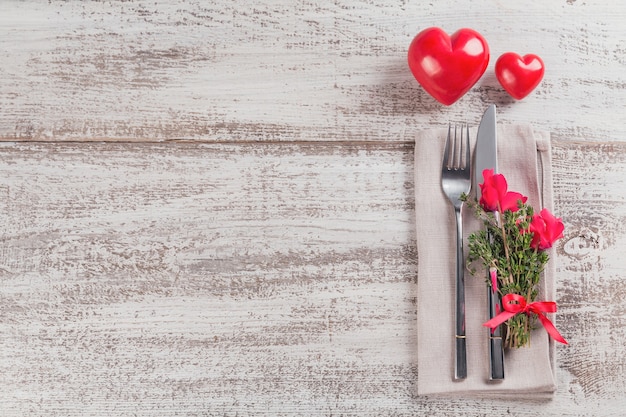 Réglage de la table rustique avec des fleurs de thym et cyclamen et forme de coeur décoration sur table en bois clair