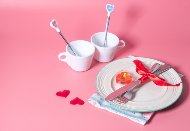 Réglage de la table de Saint Valentin avec plaque sur fond rose