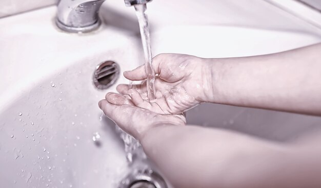 Règles d'hygiène. Lavage des mains avant les repas. Traitement antibactérien des mains avec du savon. Un moyen de prévenir l'infection virale. Protection contre le coronavirus.