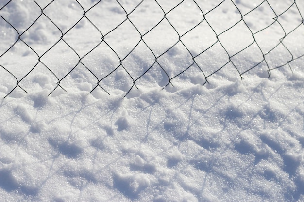 relier la clôture et la neige avec des parapluies dans la journée d'hiver dans le jardin