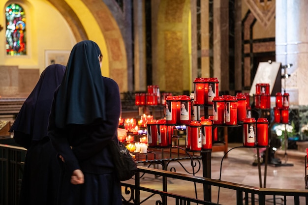 Photo des religieuses en robes traditionnelles prient dans une basilique chrétienne