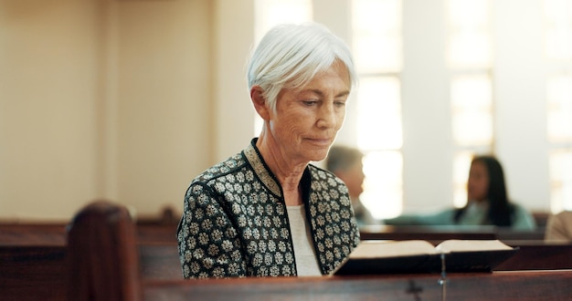 La religion biblique et une femme âgée dans une église pour un sermon sur la foi ou la croyance chrétienne tout en étant assis dans un banc Le culte de la prière ou la lecture avec une personne âgée entendant parler de Dieu et de Jésus