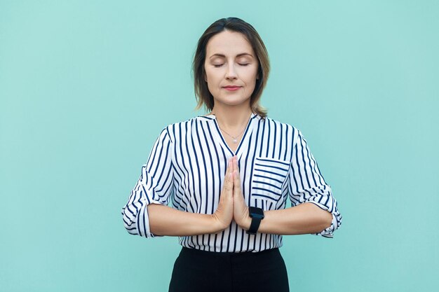 Religion de méditation et pratiques spirituelles belle femme d'affaires faisant du yoga à l'intérieur à la lumière