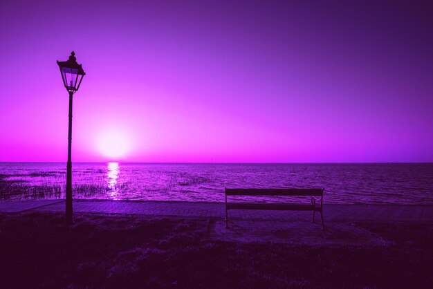 Remblai du lac avec lampe de rue et banc le soir avec ciel violet spectaculaire Coucher de soleil sur le lac Balaton Hongrie