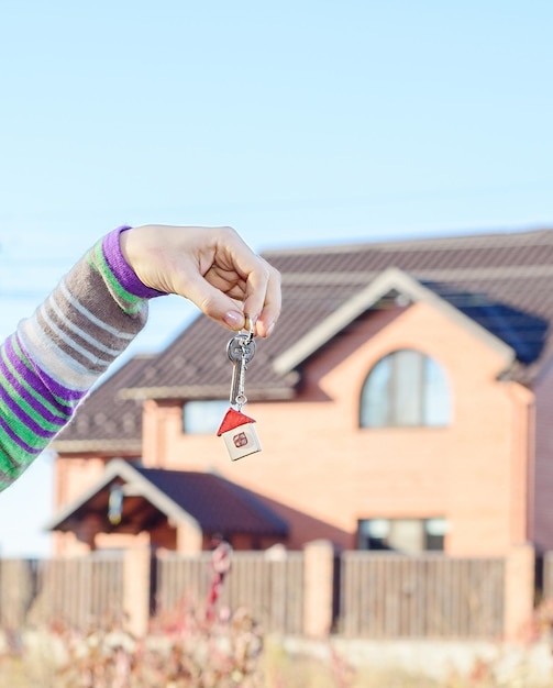 Remise des clés de la maison devant une belle maison neuve