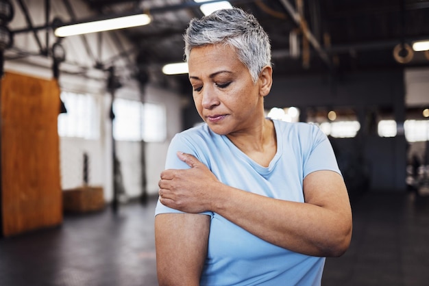 Remise en forme de la douleur à l'épaule et femme âgée à la salle de sport en entraînement ou exercice de perte de poids avec risque pour la santé Blessure musculaire et personne âgée ou athlète dans un accident de bras d'épuisement sportif ou d'arthrite