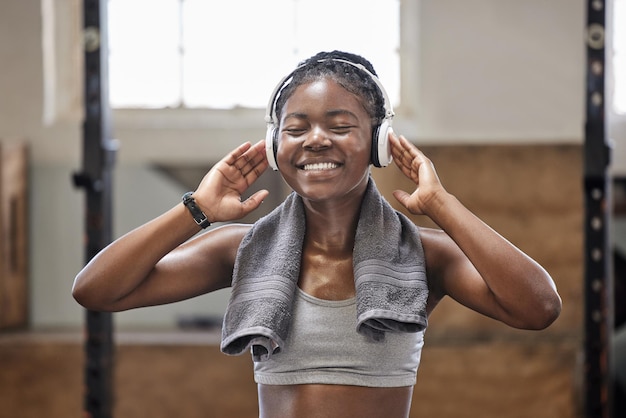 Remise en forme énergétique et musique avec un athlète noir heureux s'entraînant à la salle de sport en streaming motivation podcast en ligne Une femme afro-américaine aime faire de l'exercice et un mode de vie sain se détendre et soulager le stress cardio