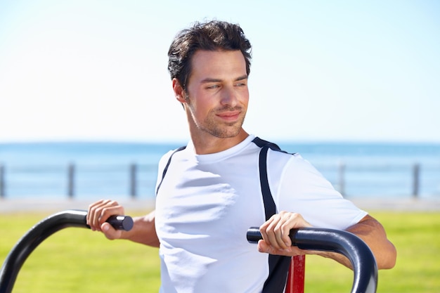 Remise en forme de l'homme et presse à l'épaule au parc pour faire de l'exercice ou s'entraîner dans la nature près de la salle de sport de la plage.