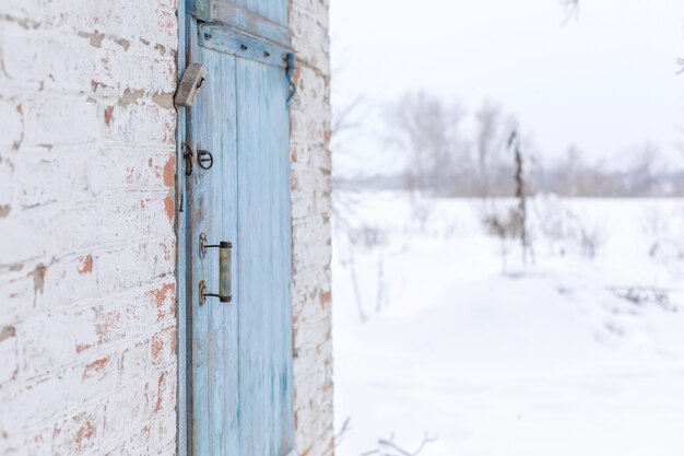 Remise avec une porte en bois bleu. Hiver