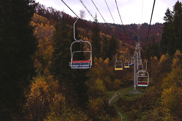 Remontée mécanique dans les montagnes d'automne parmi de belles vues avec des arbres jaunes et rouges concept Wanderlust