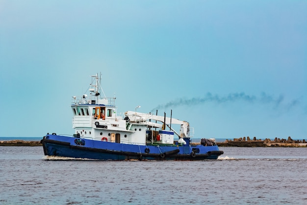 Remorqueur bleu se déplaçant vers le terminal de fret. Services industriels