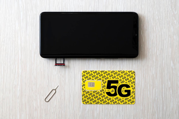 Remplacement d'une carte SIM 4G par une carte SIM 5g haute vitesse en gros plan sur la table en bois du magasin