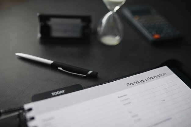 Remplir un formulaire avec des informations personnelles. Documents dans un dossier sur la table à remplir. Informations manuscrites sur le demandeur.