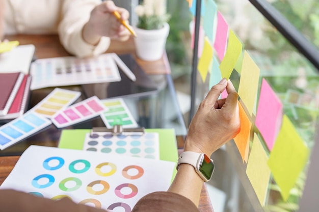 Remue-méninges sur le travail d'équipe Idée créative Projet d'entreprise Réunion de gens d'affaires prenant des notes tout en discutant avec des échantillons d'échantillons de couleur pour partager une idée