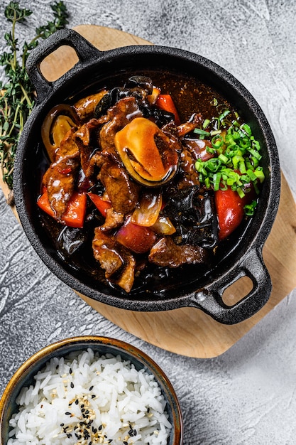 Remuer la viande de boeuf dans une sauce aux huîtres avec du riz. Fond blanc. Vue de dessus