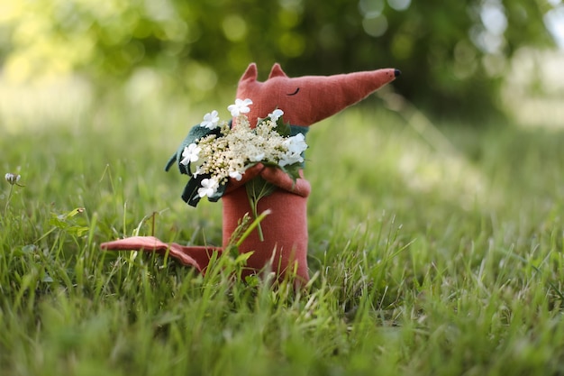 Renard de jouet fait main mignon drôle sur l'herbe au jour ensoleillé d'été