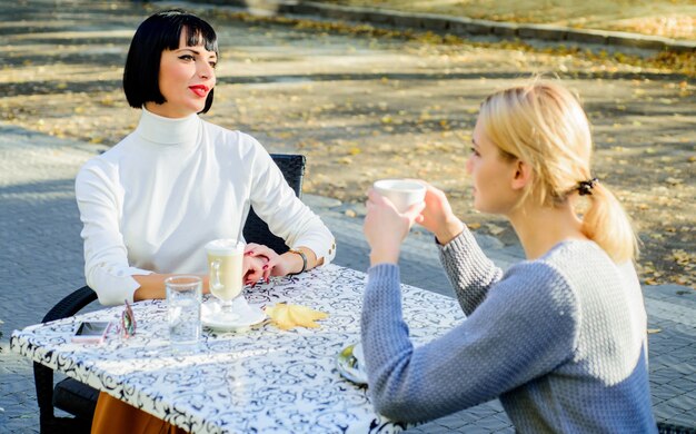 Rencontre d'amitié. Partage de pensées. Amitié féminine. Communication de confiance. Les amies boivent du café et parlent. Conversation de deux femmes terrasse de café. Vraie amitié amicale relations étroites.