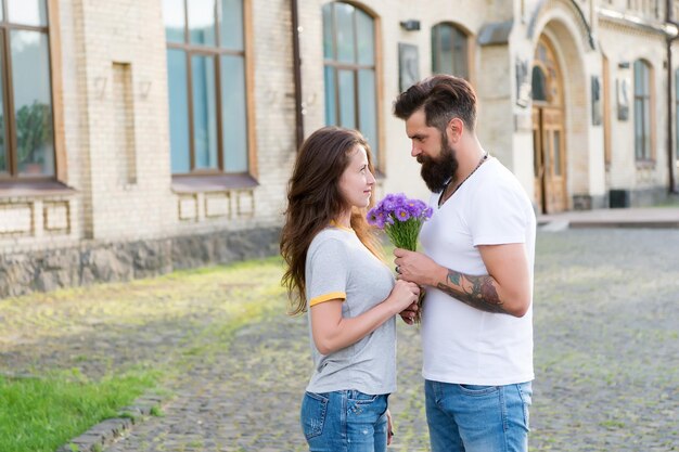 Rencontre de couple pour rendez-vous Bouquet cadeau Homme donnant un bouquet de fleurs Rendez-vous romantique Guy a préparé un bouquet surprise pour petite amie Vrais sentiments Ramasser une fille pour rendez-vous Hipster barbu tomber amoureux