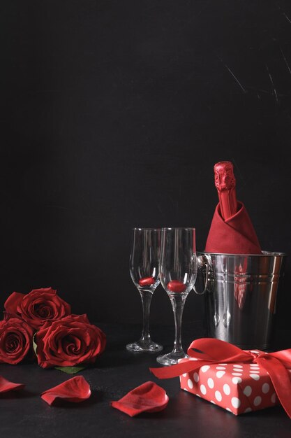 Rencontres romantiques avec bouquet cadeau vin mousseux de roses rouges sur célébration noire pour la Saint-Valentin