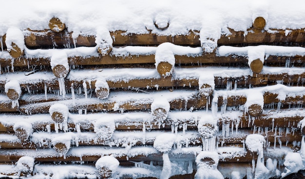 Renforcement du mur en bois rondins sous la neige en hiver