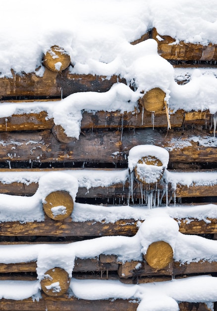 Renforcement des rondins, mur en bois sous la neige en hiver