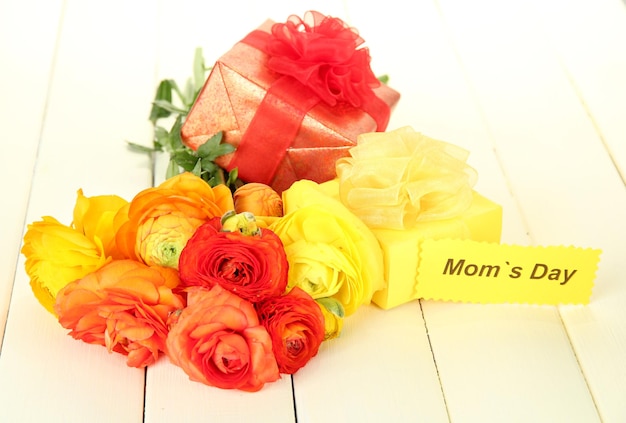 Renoncules (renoncules persans) et cadeaux pour la fête des mères, sur fond de bois blanc
