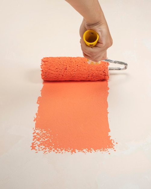Rénovation domiciliaire peindre le mur avec de la peinture au rouleau orange