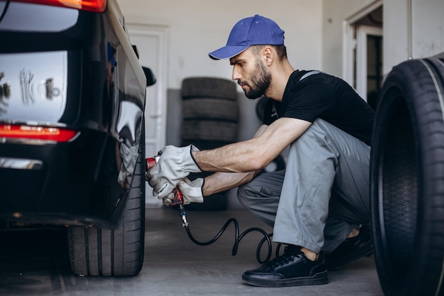 Réparateur au service de voiture changeant les pneus