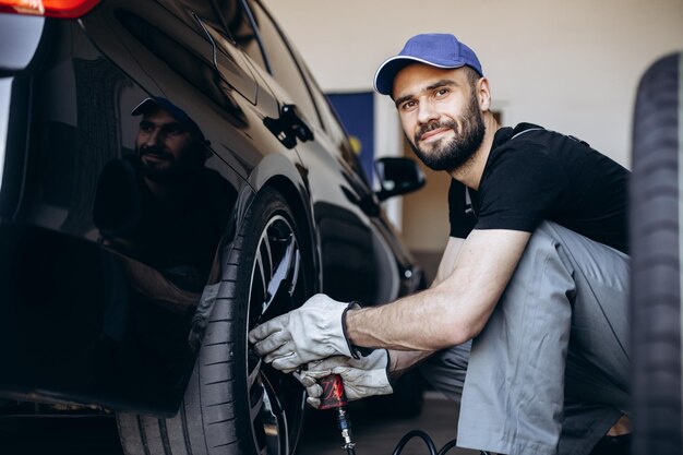 Réparateur au service de voiture changeant les pneus