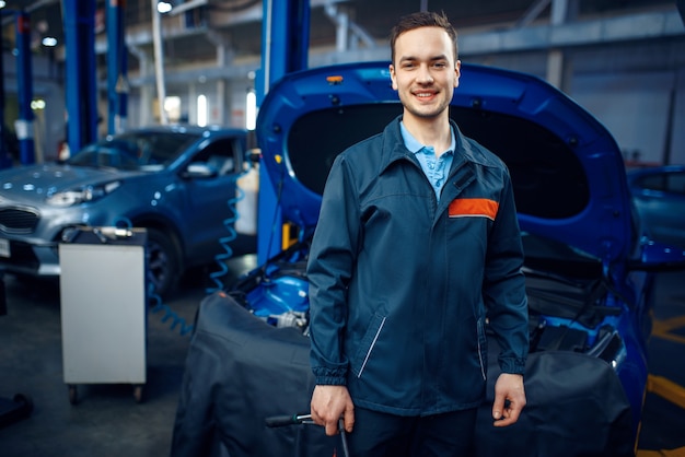 Réparateur au véhicule avec capot ouvert, service de voiture