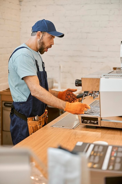 Réparateur choqué fixant la machine à café au café