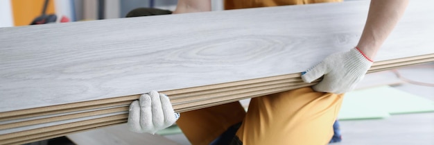 Un réparateur en uniforme tient les panneaux de stratifié en gros plan