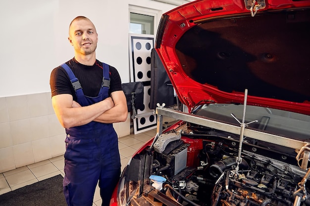 Réparation d'un moteur de voiture dans un centre d'autoservice Mécanicien automobile travaillant dans le garage