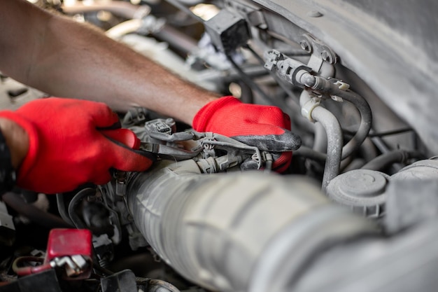 Réparations automobiles Le mécanicien automobile déconnecte le tuyau d'air du moteur de la voiture