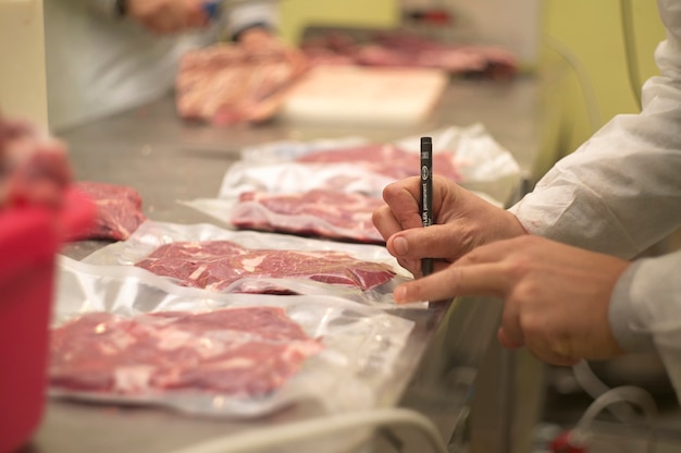 Reparto di una macelleria in cui vengono tagliati i pezzi di carne per poi essere messi dentro a buster di plastica per essere conservata sottovuoto.