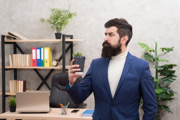 Repas d'affaires. Homme d'affaires en tenue formelle au déjeuner. Un homme confiant utilise un ordinateur portable. Lieu de travail du patron. Pause café, déjeuner. Homme barbu au bureau d'affaires. Il est l'heure de déjeuner. inspiré avec une tasse de café frais.