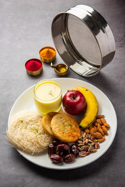 Photo repas avant l'aube de sargi pour karwa chauth ou karva chauth puja servi avec chalni ou passoire et diya