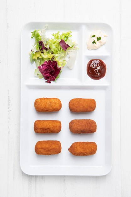 Repas à base de croquettes et salade