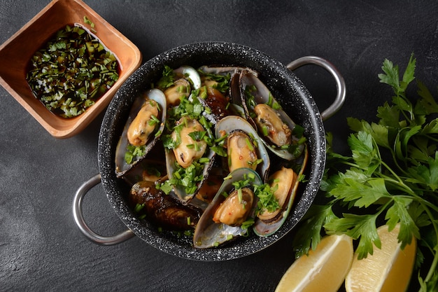Photo repas français classique moules marinière moules marinara avec ail, sauce, citron et persil.