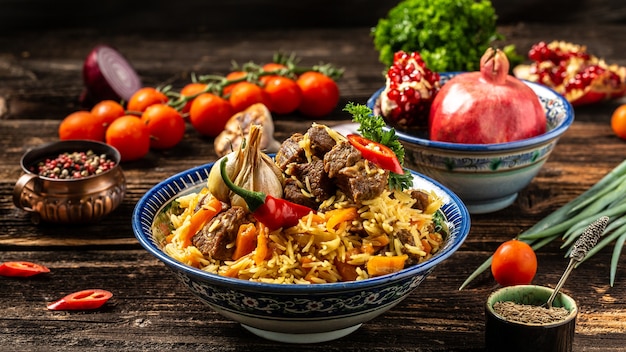 Repas traditionnel ouzbek appelé pilaf. Riz à la viande, carottes et oignons en assiette avec ornement oriental, cuisine orientale ouzbek. Format de bannière longue. espace pour le texte.