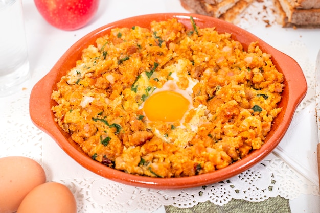 Repas traditionnel portugais de saucisse alheira mixte avec œuf et persil.