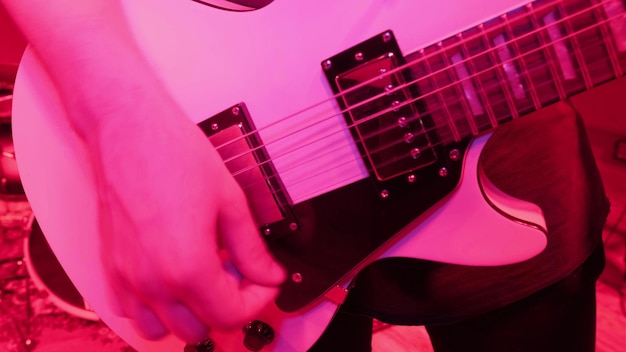 Répétition d'un groupe de musique rock Image recadrée d'un joueur de guitare électrique dans un feu rouge