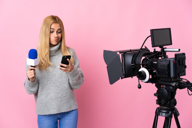 Photo reporter femme tenant un microphone et rapportant des nouvelles sur la pensée rose isolée et l'envoi d'un message