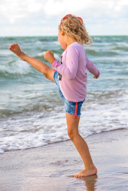 Repos au bord de la mer. Petite fille joue avec du sable sur la plage. Fille jouant avec des jouets au bord de la mer