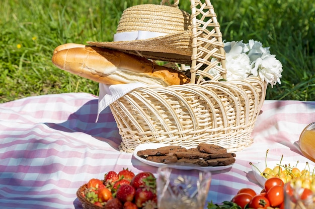 Repos à l'extérieur de la ville Baguette française et fleurs dans un panier recouvert d'un chapeau de paille Pique-nique