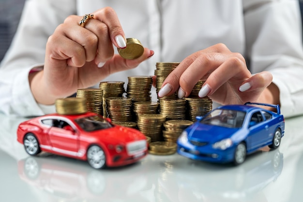 Représentant d'assurance femme assis à une table avec des pièces de monnaie et une mini voiture