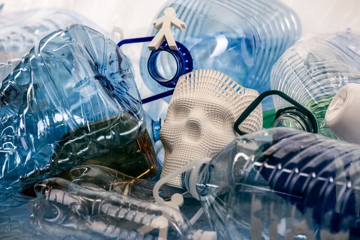 Représentation du problème. Modèles en plastique de personnes et de crânes allongés dans un tas d'ordures en plastique et présentant l'état de notre planète