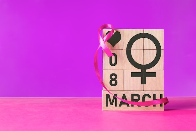 Représentation puissante de la Journée internationale de la femme avec le symbole de Vénus sur des blocs de bois