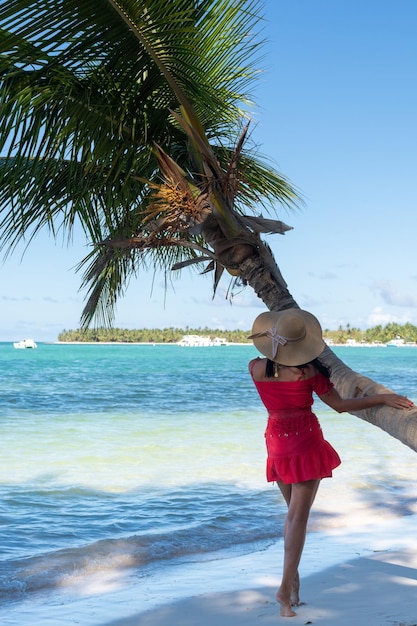 République dominicaine de Punta Cana une fille dans un chapeau sur l'océan avec de l'eau turquoise et des palmiers